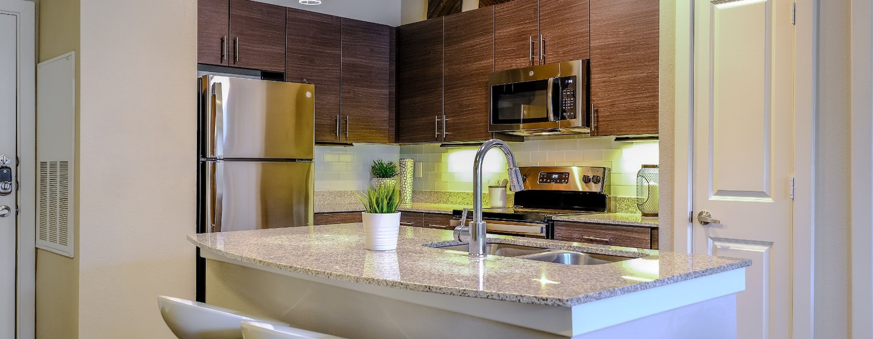 a kitchen with wooden cabinets and chairs