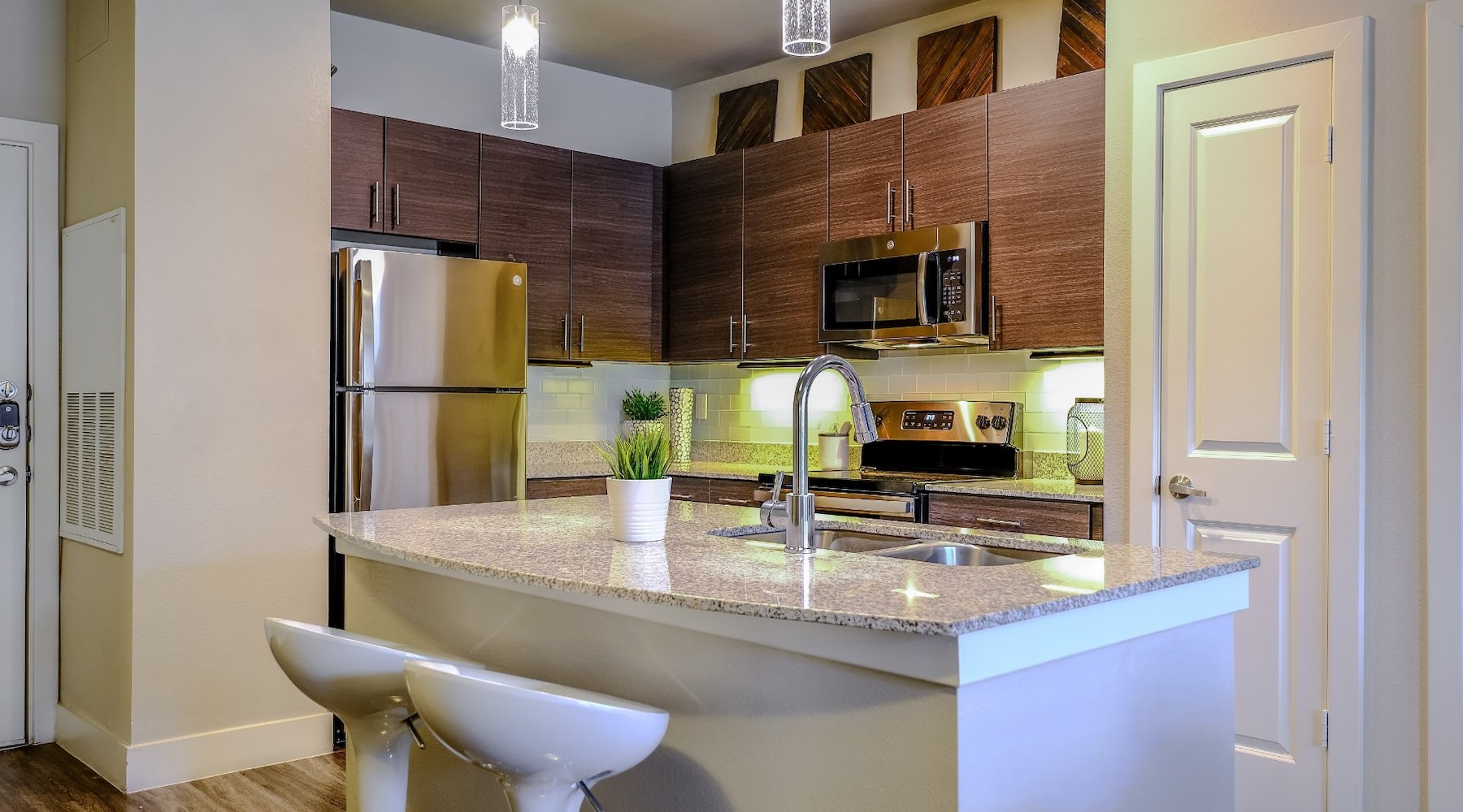 a kitchen with wooden cabinets and chairs