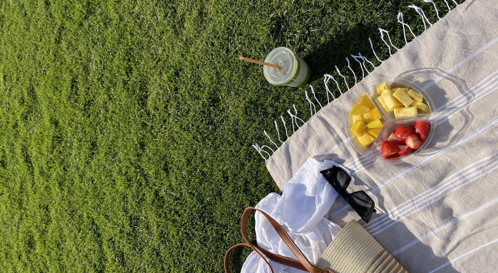 A beautiful community at the heart of all your passions a basket of fruit and a pair of sunglasses on a blanket
