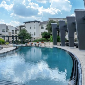 a pool in a courtyard with buildings in the background