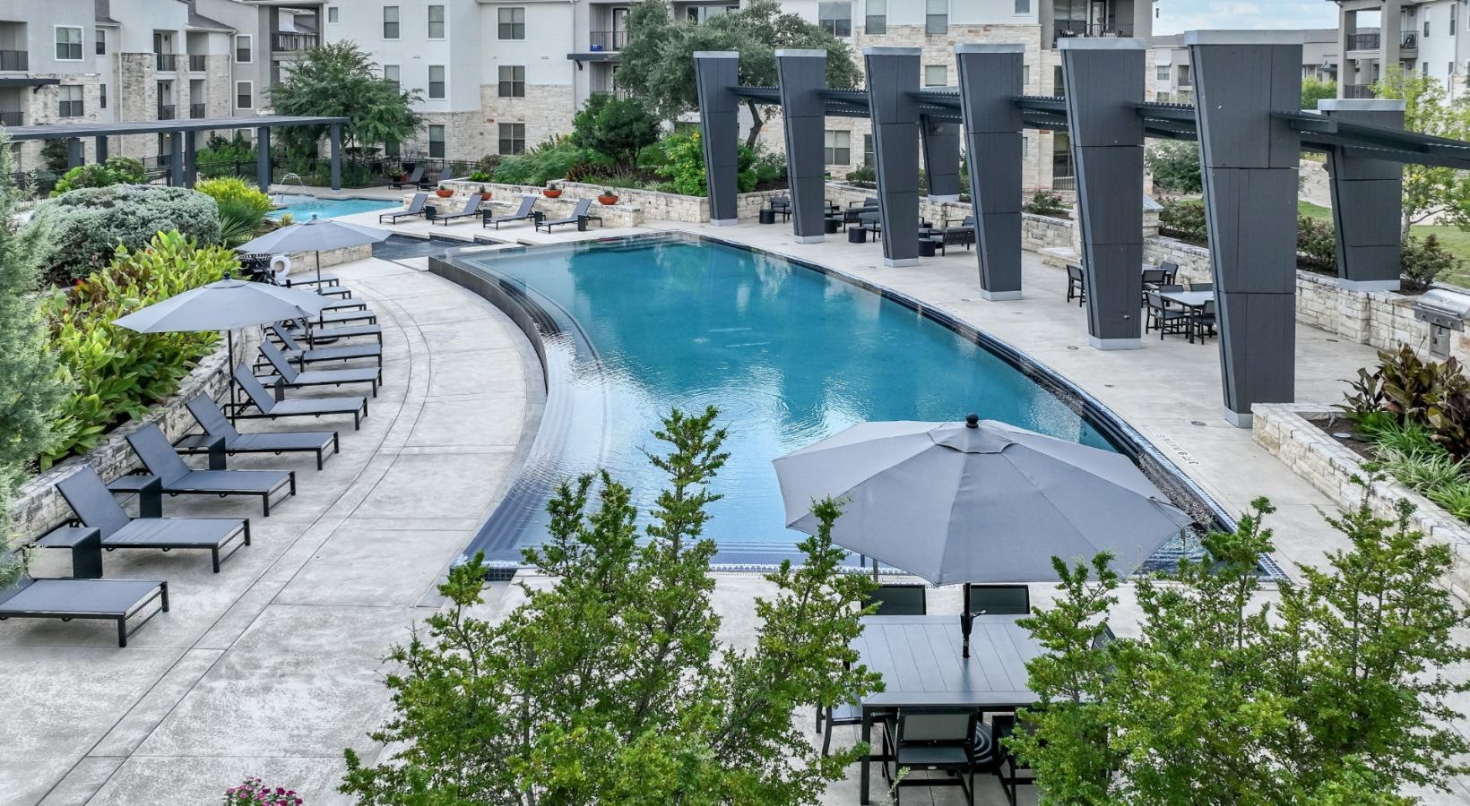 Relax and unwind poolside a pool with a building in the background