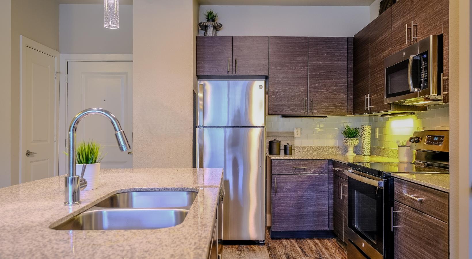 Spacious kitchens with thoughtful details a kitchen with a stainless steel refrigerator