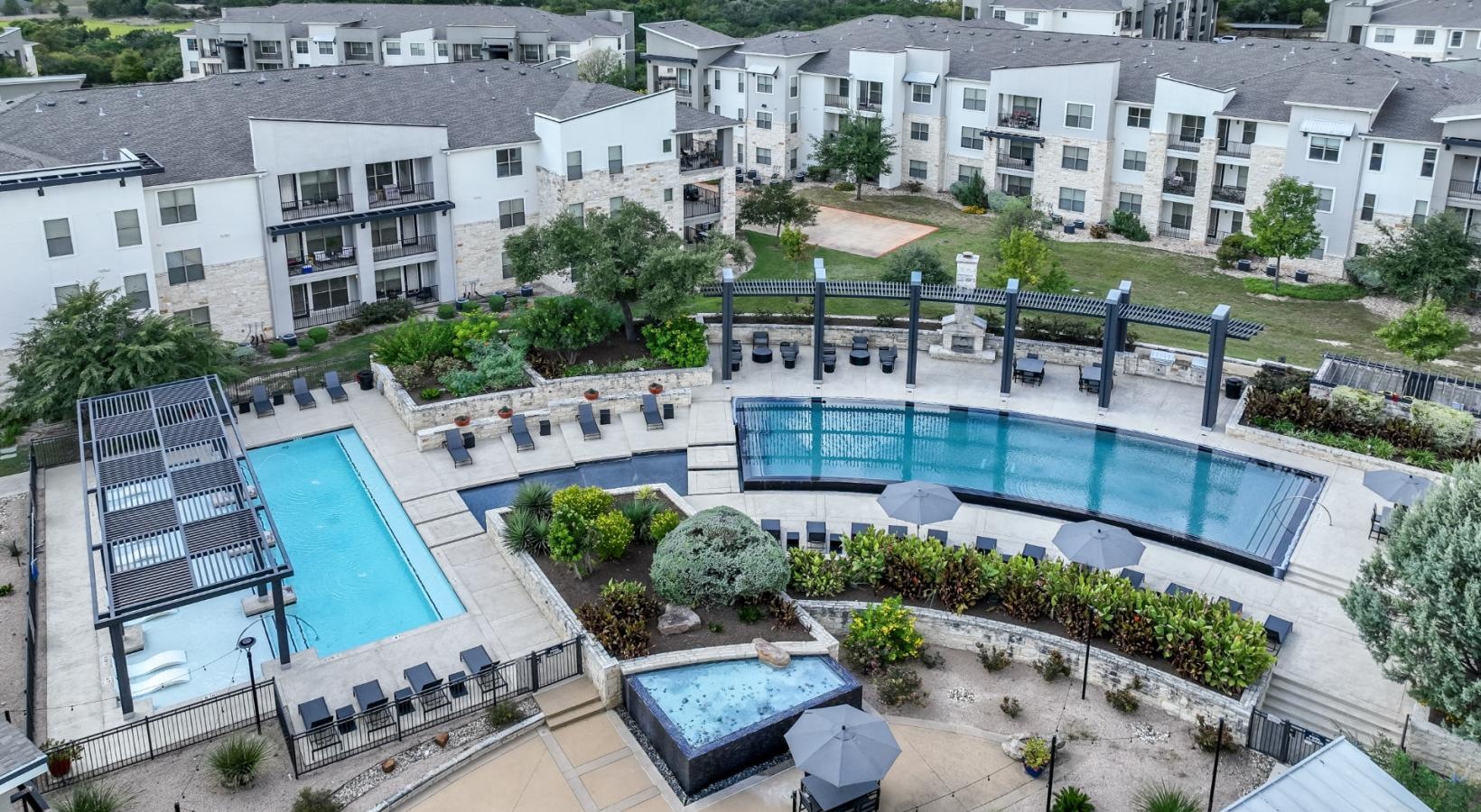 Settle into comfort at The Allure a pool in a courtyard with buildings in the background