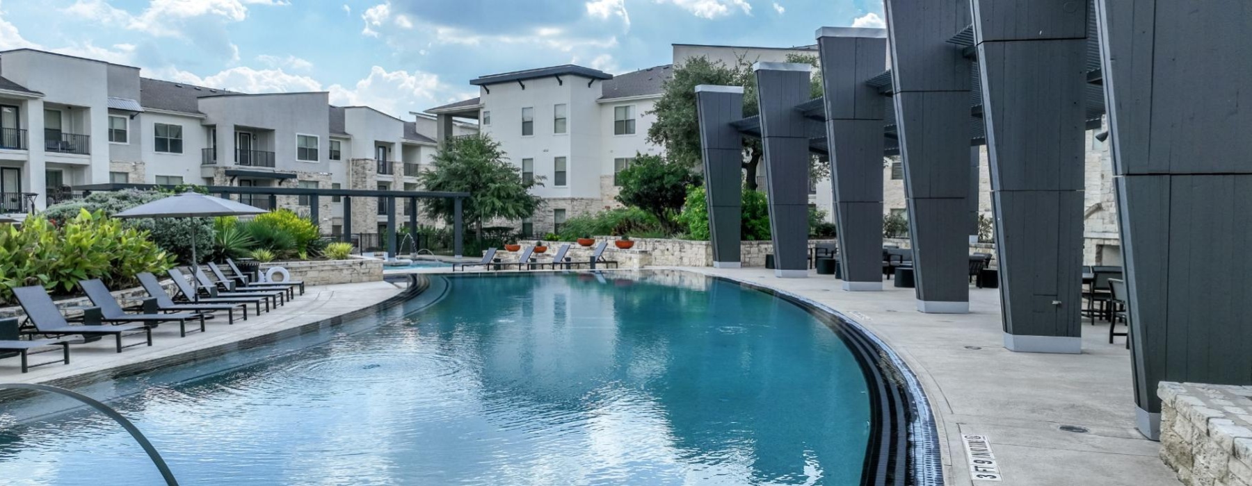 a pool in a courtyard with buildings in the background