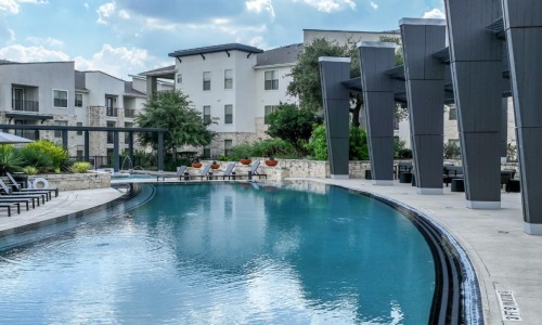 a pool in a courtyard with buildings in the background