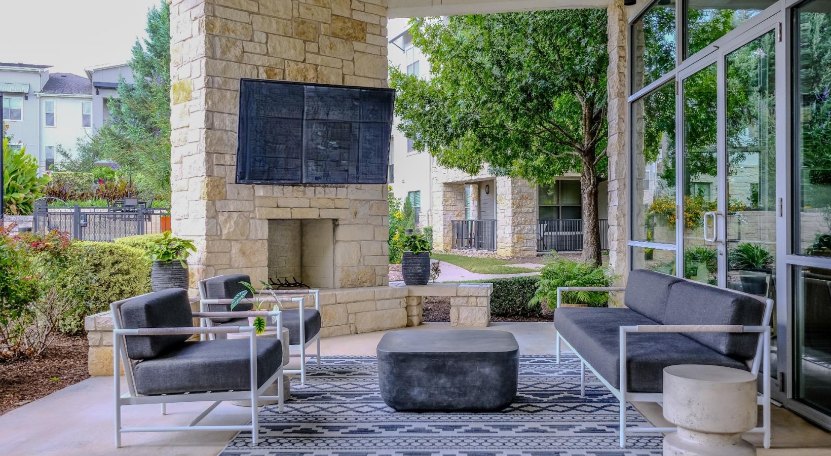Take advantage of all The Allure has to offer a patio with a fireplace and a stone fireplace