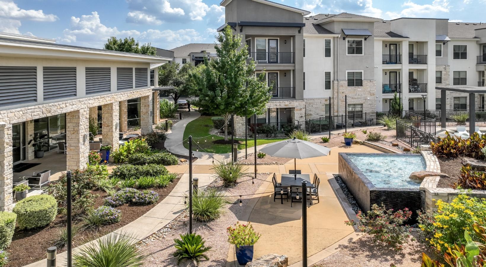 Settle into comfort at The Allure a courtyard with a building in the background